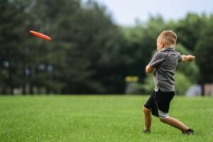 little kid throwing a frisbee