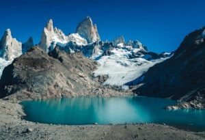 a small lake beneath snow capped peaks