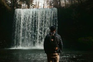 hiker in front of waterfall