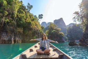 woman sitting in the front of a small boat on a river