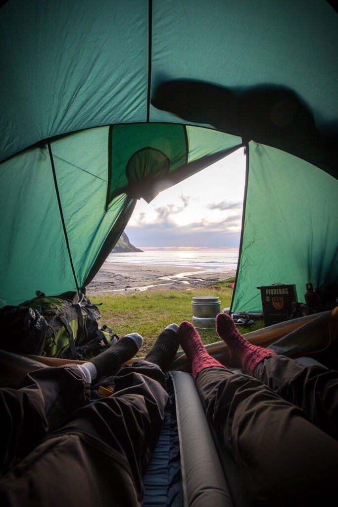 two campers looking out of their tent