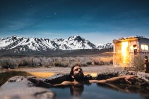 man resting in a natural pool in the wilderness